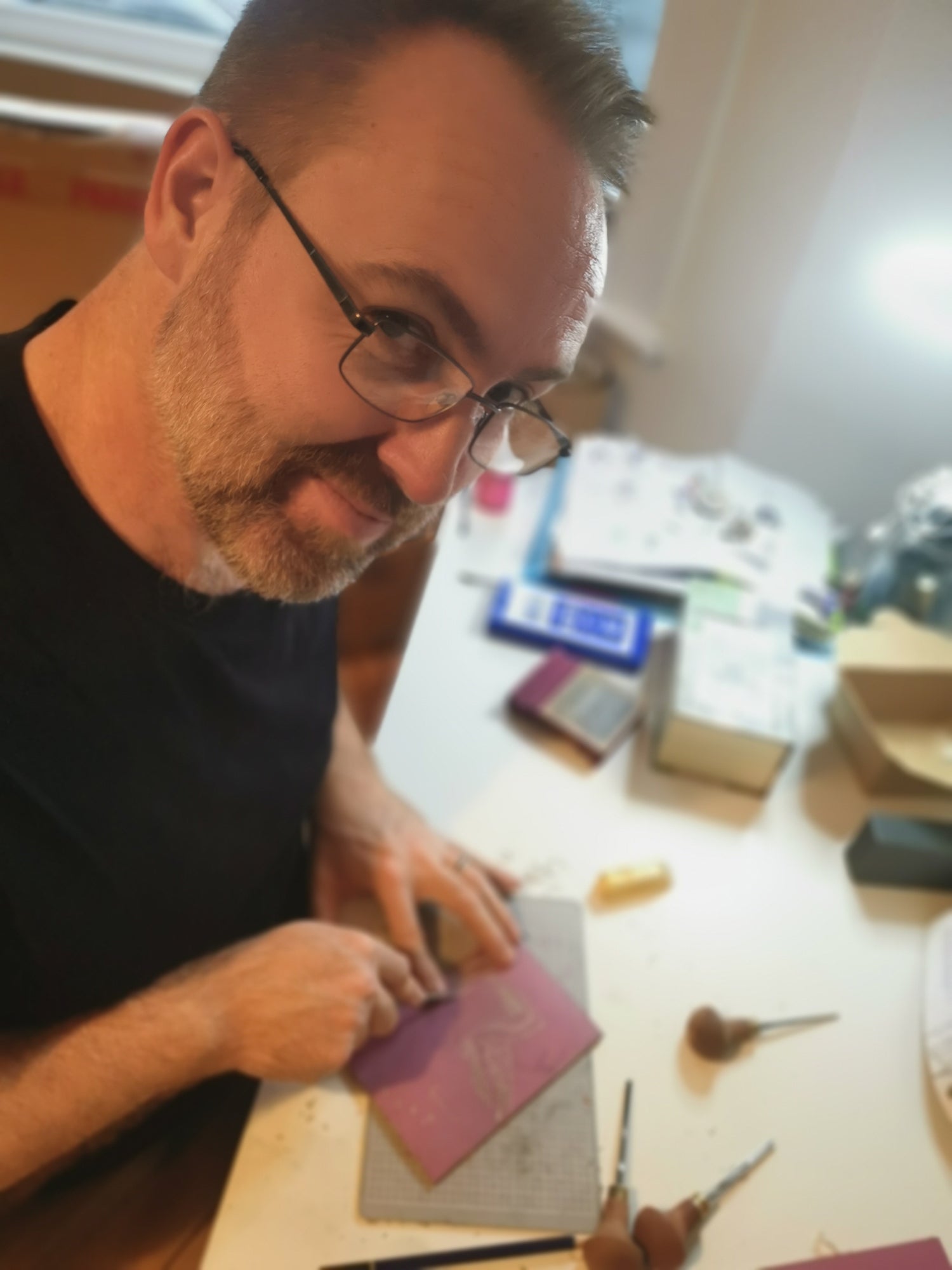 Al (man) with glasses working on a linocut project at a table