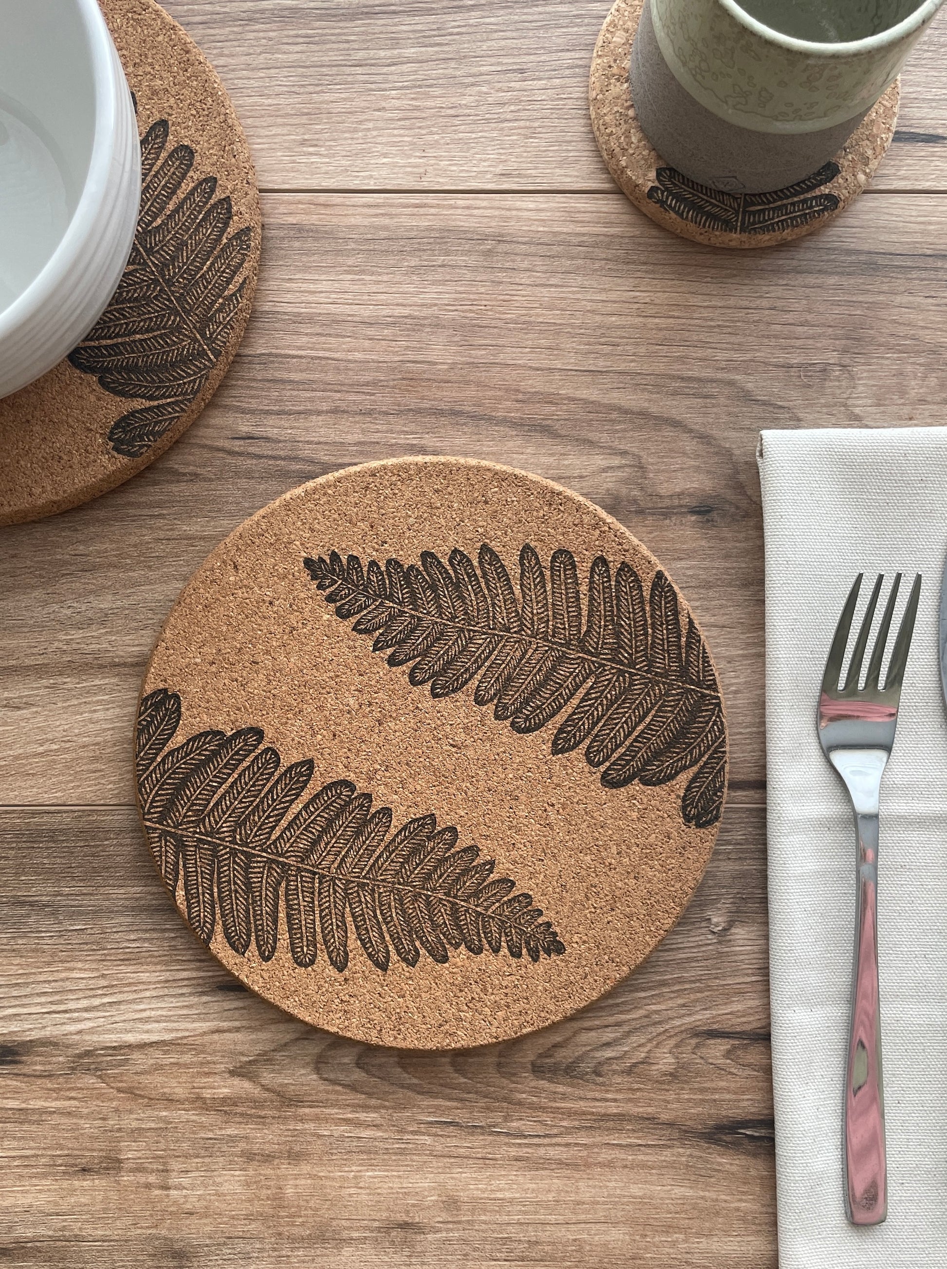 Fern linocut printed cork placemat with table setting including bowl, cup and napkin with cutlery