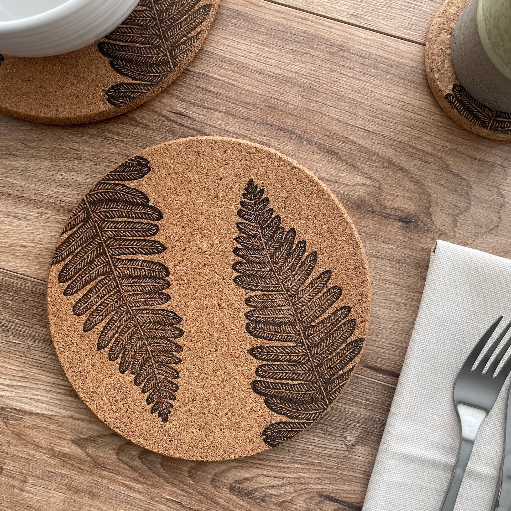 Fern linocut printed cork placemat with table setting including bowl, cup and napkin with cutlery