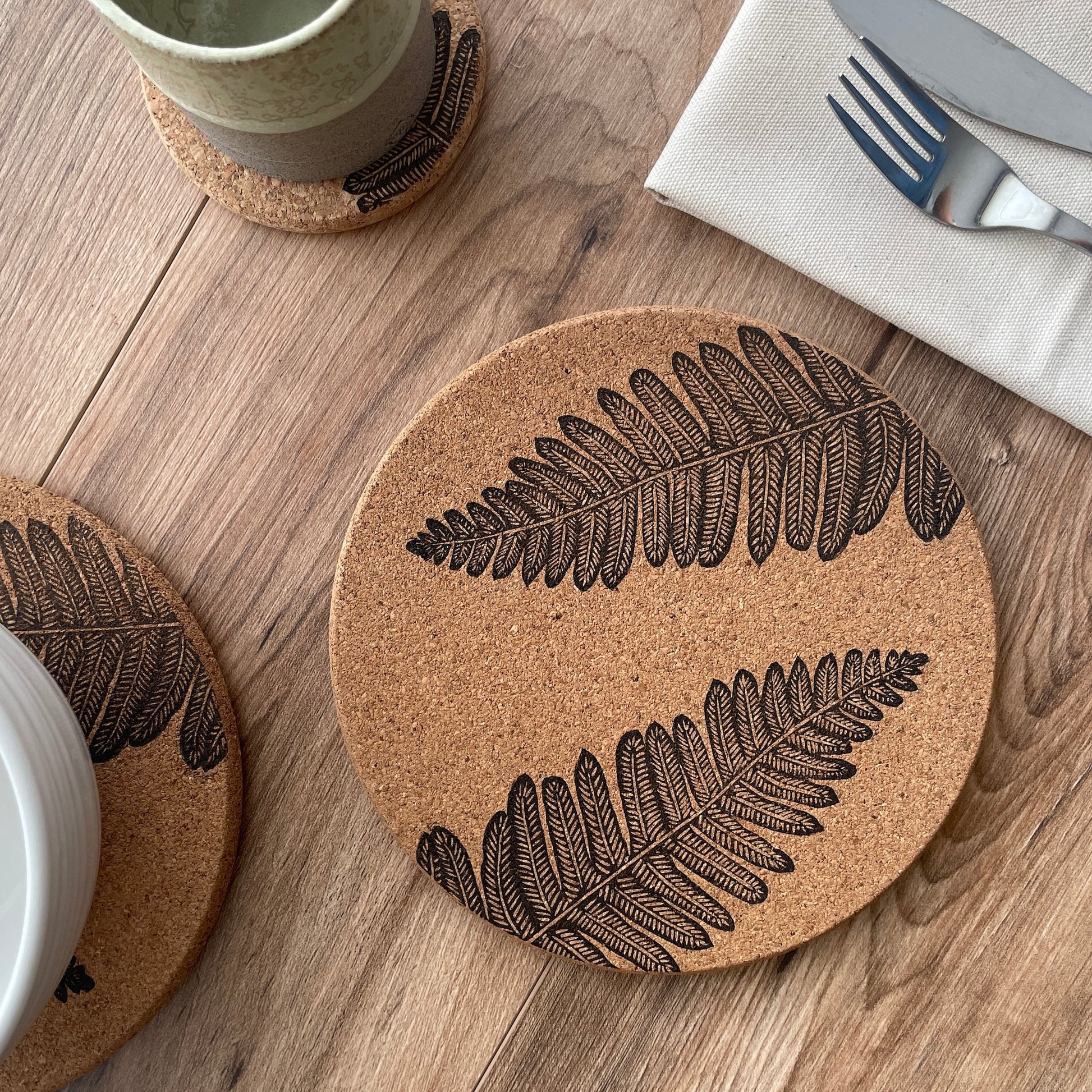 Fern linocut printed cork placemat with table setting including bowl, cup and napkin with cutlery