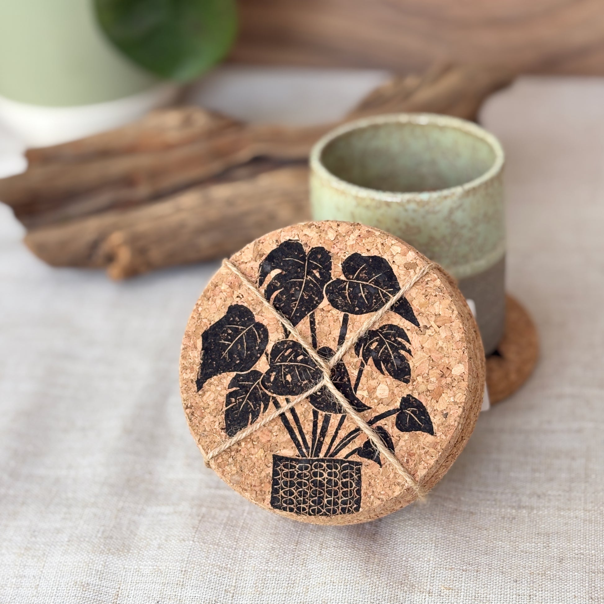 Cork coaster with leaf design on a linen tablecloth