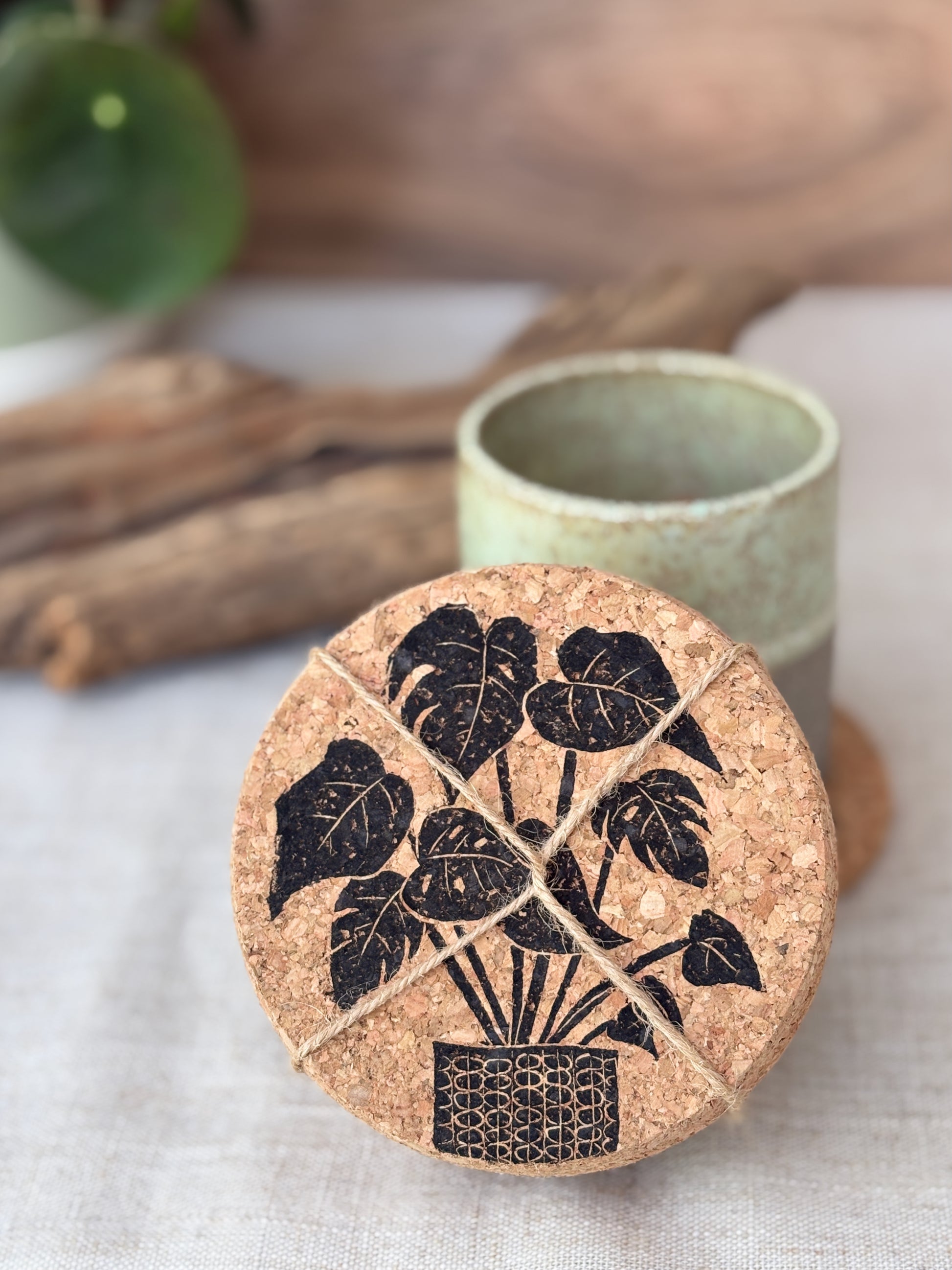 Cork coaster with plant design on a white surface